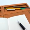 Ergonomiczna podstawka pod laptopa LapPad w kolorze Oregon z przegródkami na długopis, ołówek i notatnik, przygotowana do pracy zdalnej.
