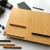 LapPad – ergonomiczna podstawka pod laptopa w naturalnym kolorze sklejki z pomarańczową, czarną i złotą listewką oraz kolorowymi kluczykami montażowymi