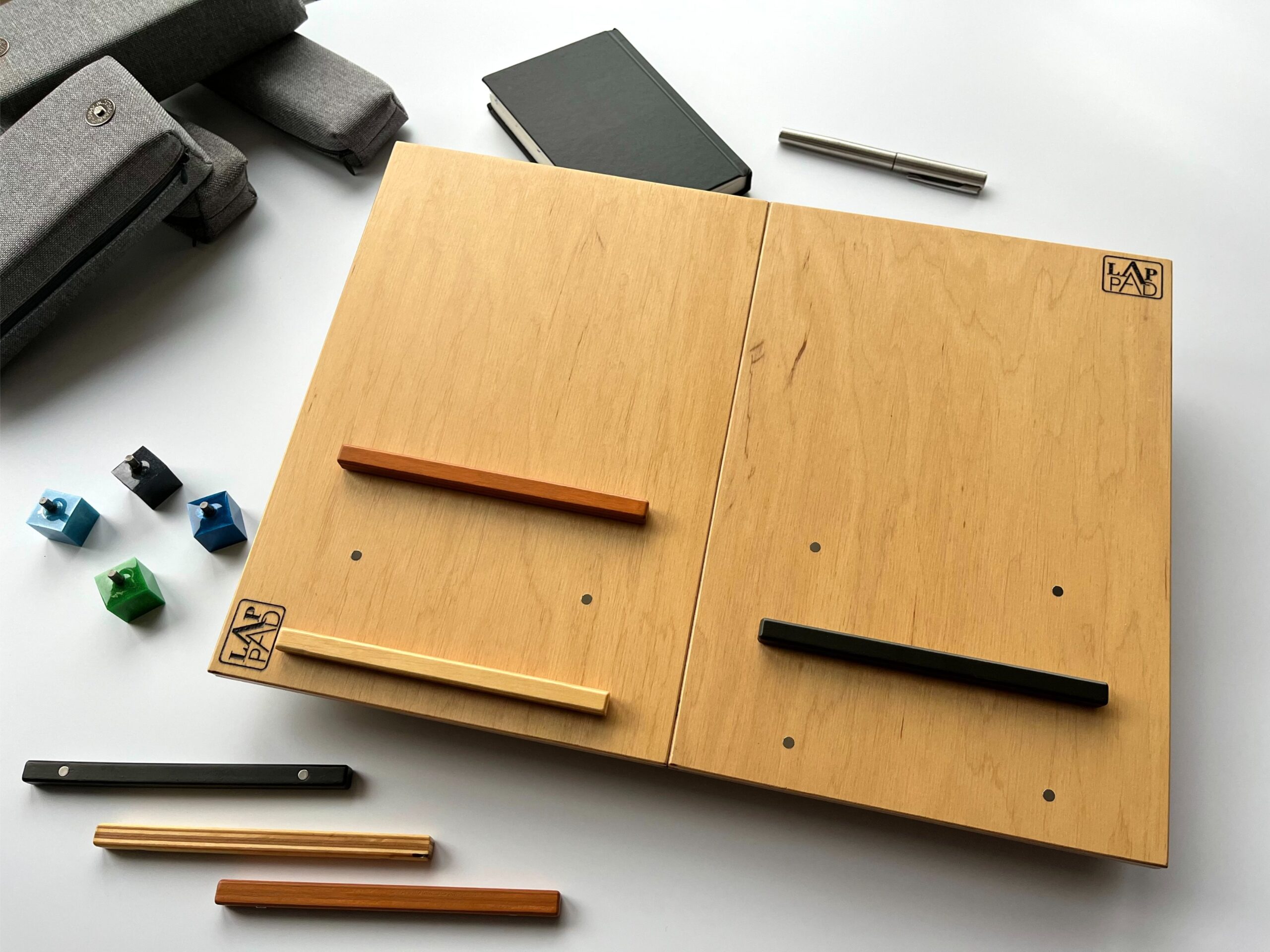 LapPad – ergonomiczna podstawka pod laptopa w naturalnym kolorze sklejki z pomarańczową, czarną i złotą listewką oraz kolorowymi kluczykami montażowymi