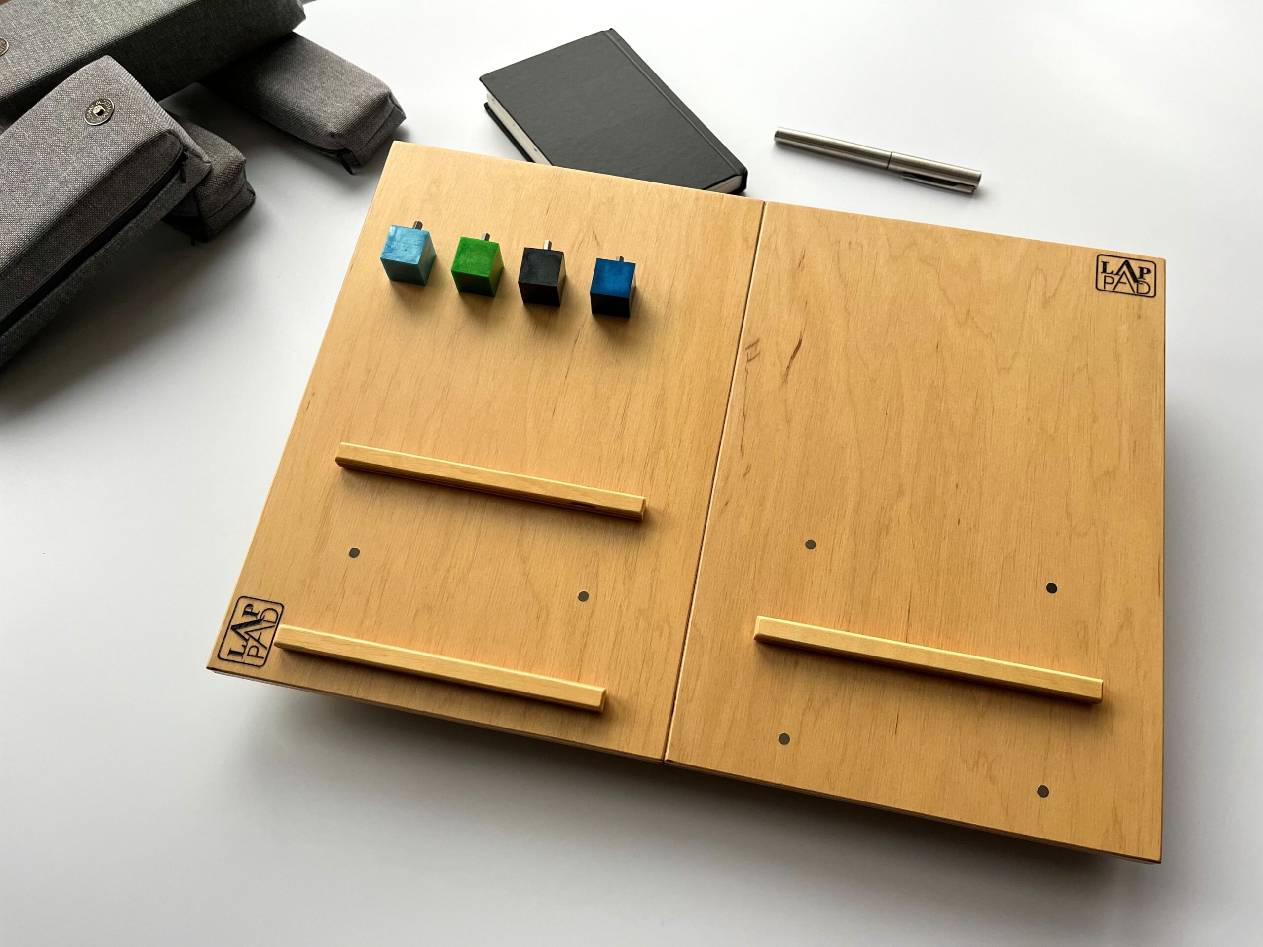 LapPad – ergonomiczna podstawka pod laptopa w naturalnym kolorze sklejki z jasnymi listewkami i kolorowymi kluczykami montażowymi.