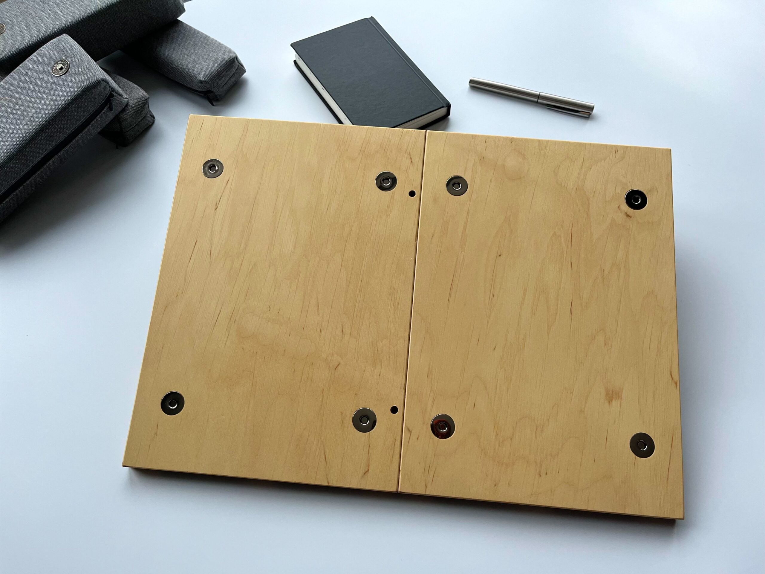 Spód podstawki pod laptopa LapPad w naturalnym kolorze sklejki z widocznym systemem mocowania i metalowymi elementami.