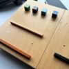 Ergonomiczna podstawka pod laptopa LapPad – kolorowe listewki pomocnicze i kluczyki montażowe na powierzchni ze sklejki.