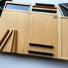 Ergonomiczna podstawka pod laptopa LapPad – listewki pomocnicze w naturalnym kolorze sklejki, czarne moduły i ozdobne wykończenie z żywicy epoksydowej.