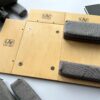 Ergonomiczna podstawka pod laptopa LapPad – elementy ze sklejki z logo i szare gąbki pozycjonujące dla poprawy stabilności i komfortu pracy.