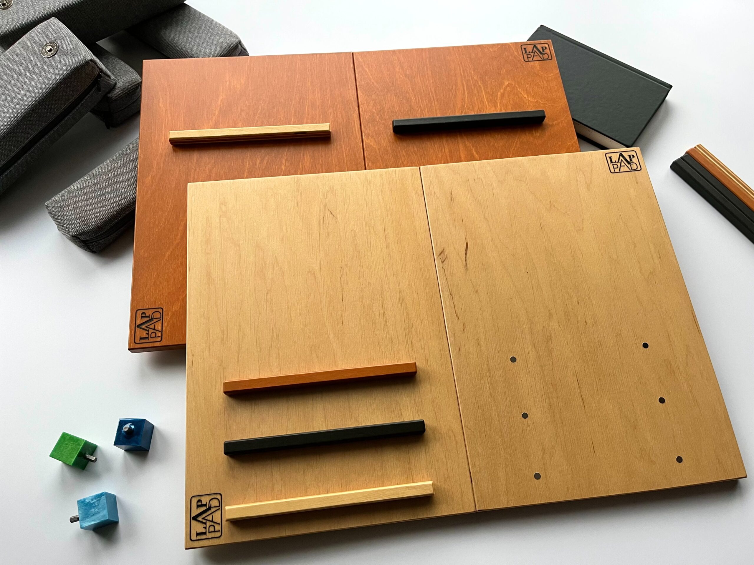 Ergonomiczna podstawka pod laptopa LapPad – elementy ze sklejki z logo, listewki pomocnicze oraz akcesoria montażowe, tworzące funkcjonalne miejsce pracy.